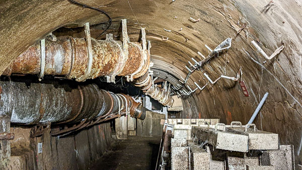 Old, cobweb-encrusted sewer pipes in Paris Sewers Museum.