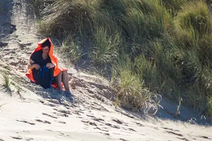 Woman resting in sand dunes, Belgium