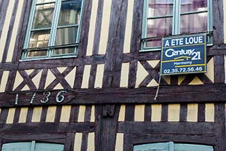 Half-timbered house in Rouen with Century 21 Real Estate sign