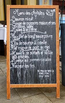 Rain-streaked blackboard menu in Honfleur