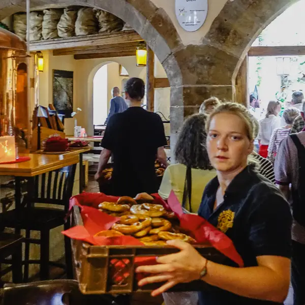 A server in a Bamberg pub carries pretzels to a table.