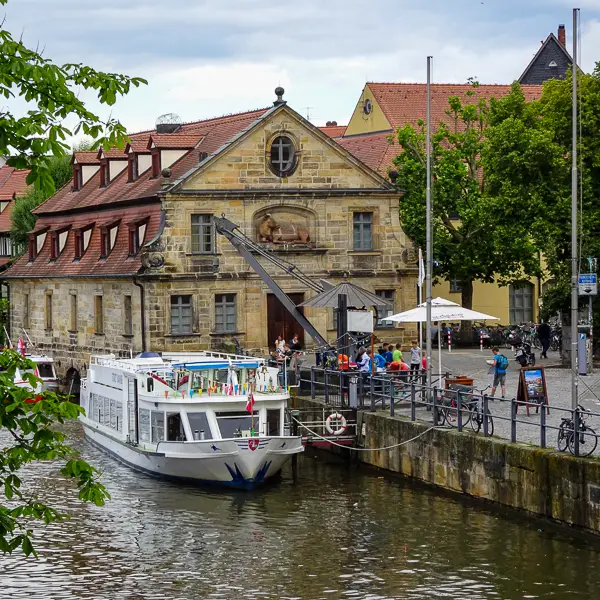 A sightseeing boat collects passengers on the Regnitz River in Bamberg, Germany.