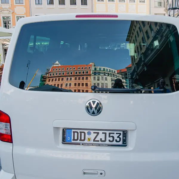 Dresden's Neumarkt is reflected in the rear window of a Volkswagen van.