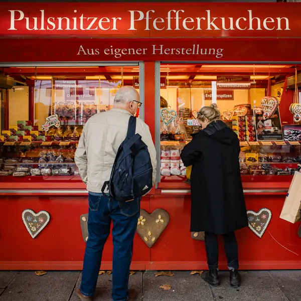 Pedestrians buy cookies from a sidewalk shop in Dresden, Germany.