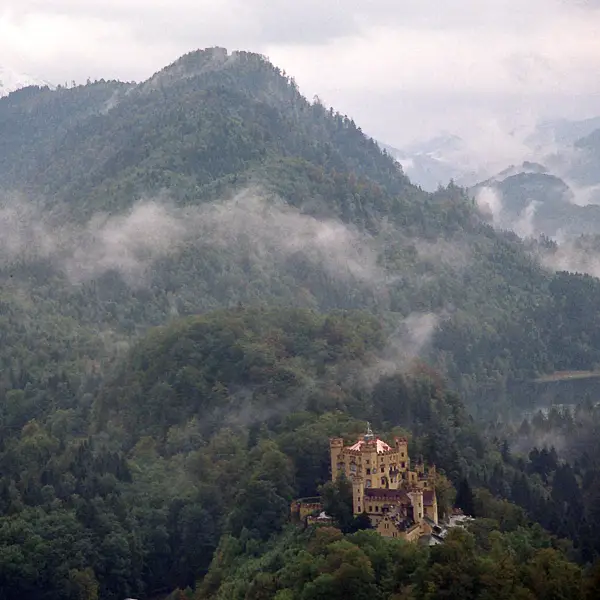 Germany's Hohenschwangau Castle sits on a foggy Bavarian hillside.