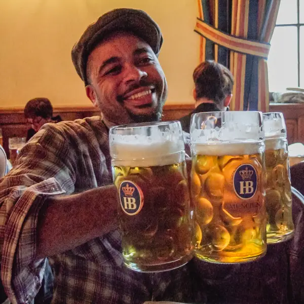 An American visitor hoists a host of mugs in Munich's Hofbrauhaus.