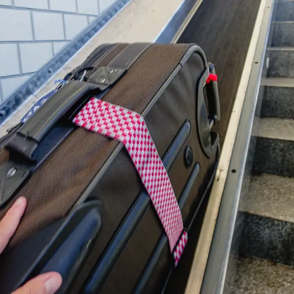 A suitcase rides a conveyor belt alongside a staircase in Nuremberg's Hauptbahnhof.