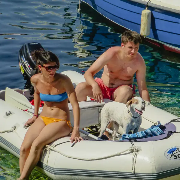 A couple and their dog share an inflatable boat in Hvar, Croatia.