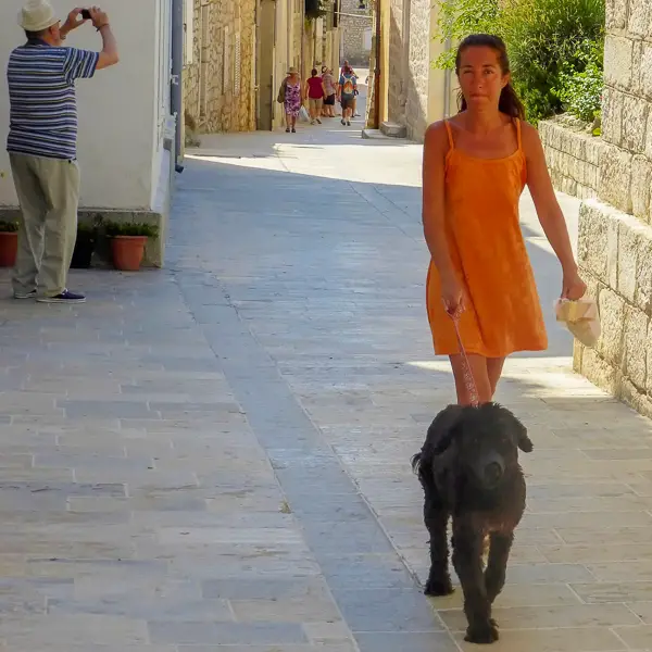A woman and her dog take a walk in Rab, Croatia.
