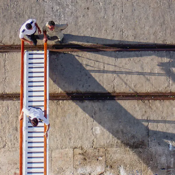 Crew members from the cruise ship Wind Surf deploy their gangway on a Spanish pier.