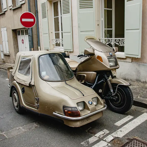 In France, a BMW motorcycle sports a covered sidecar.