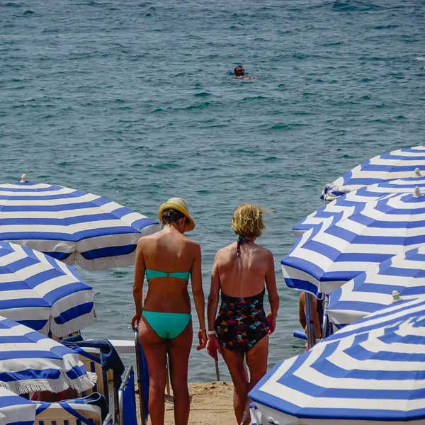 Beachgoers seek shade from umbrellas in Cannes.