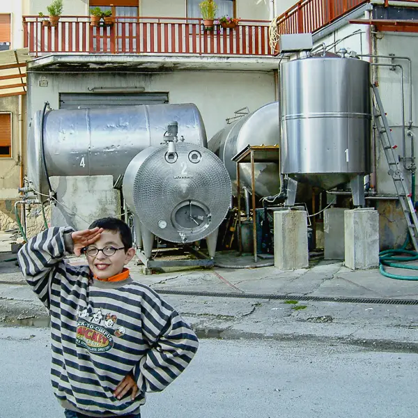 A boy salutes a visitor at a cheese factory in Italy's Basilicata region.