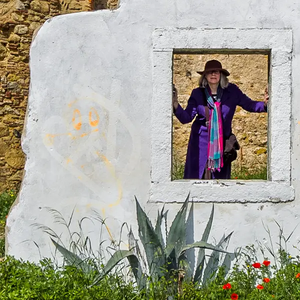 Cheryl Imboden poses with the remnants of an abandoned building in Lisbon's Alfalma district. 