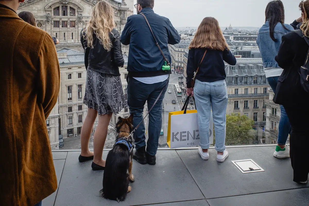 People and a dog share the Galeries Lafayette rooftop terrace in Paris.