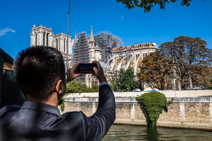 Tourist taking photo of Notre Dame Cathedral in Paris