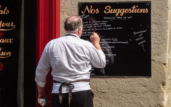 Chef and menu blackboard in Paris, France.