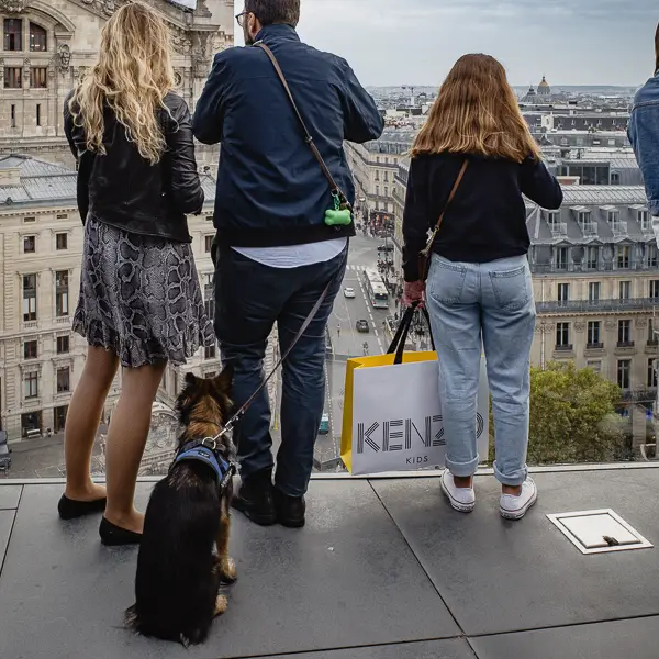 A couple and their dog enjoy the view from the Galeries Lafayette roof terrace in Paris, France.