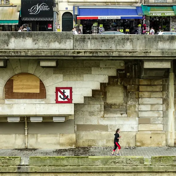 A jogger in Paris runs along the Seine.