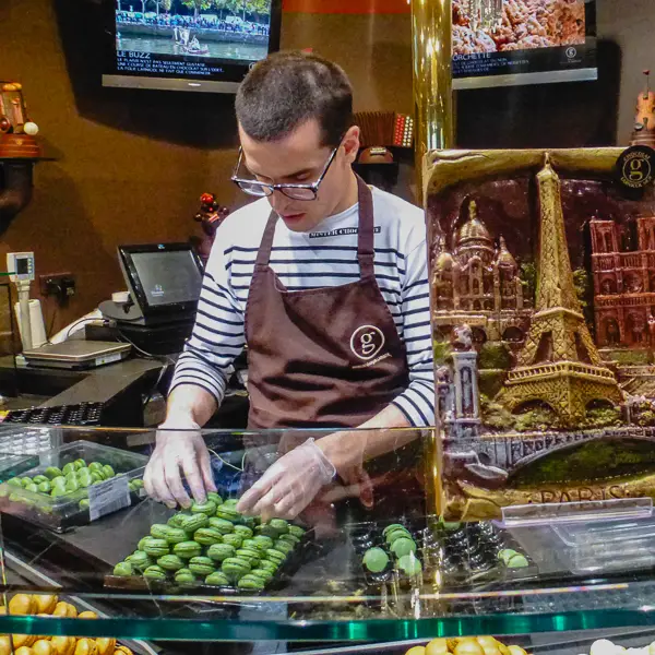 A clerk arranges macarons at the Maison Georges Larnicol.