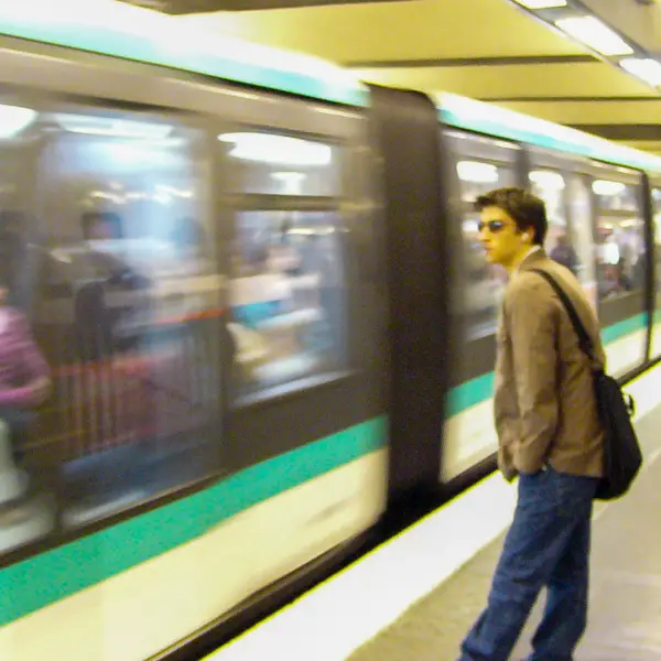 A Paris Mtro rider eyes an arriving train.