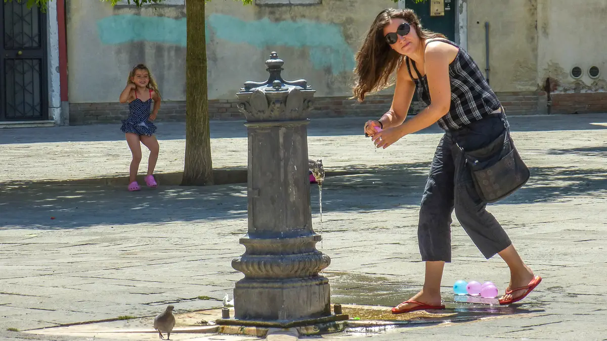 Little girl at water fountain in Venice, Italy
