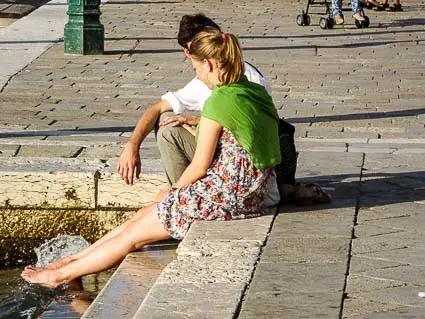 Tourist dipping feet in polluted Venice canal