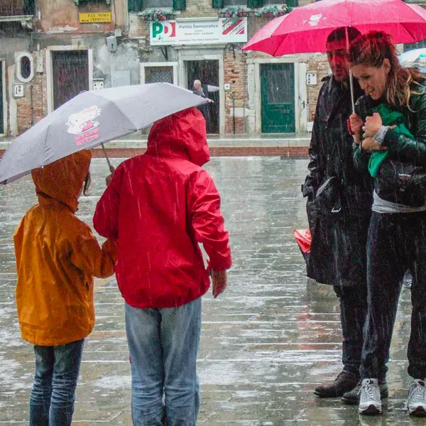 Children and their parents brave a downpour in Venice's Campo San Barnaba.