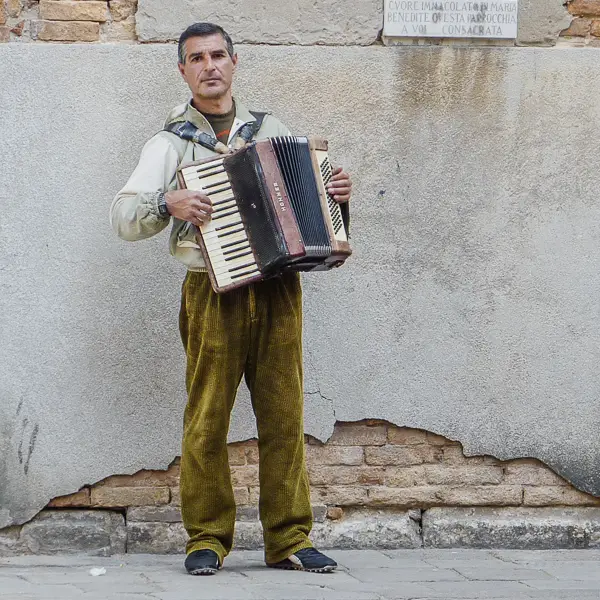 A busker performs on a street in Venice.