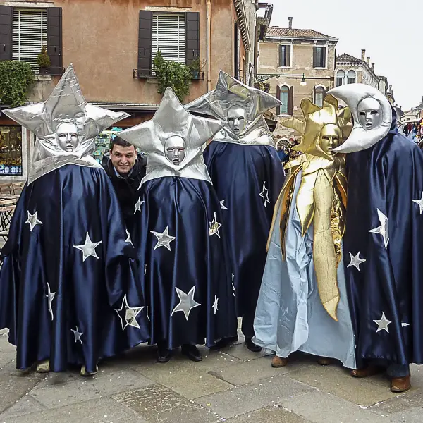 A tourist photobombs a group of Carnival participants in Venice, Italy.