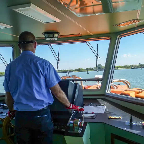 An ACTV pilot operates a public water bus in the Venetian Lagoon.