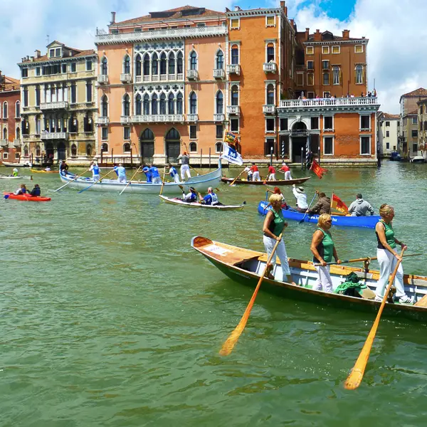 A rowing regatta roils the waters of Venice's Grand Canal.