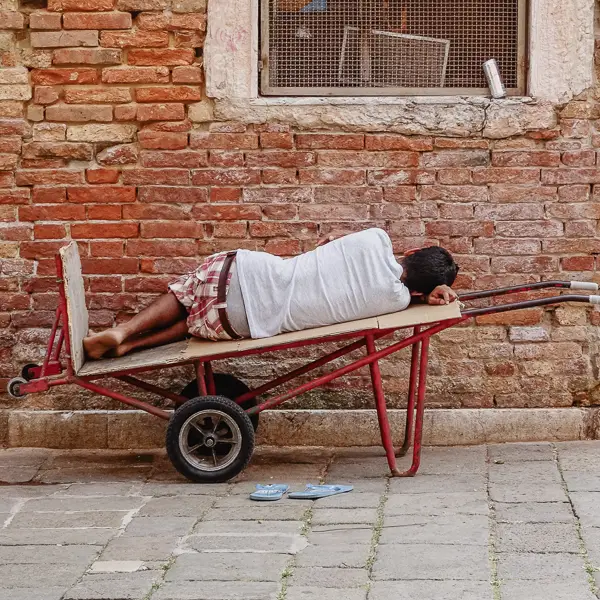 A delivery man naps on his cart in Venice's historic center.