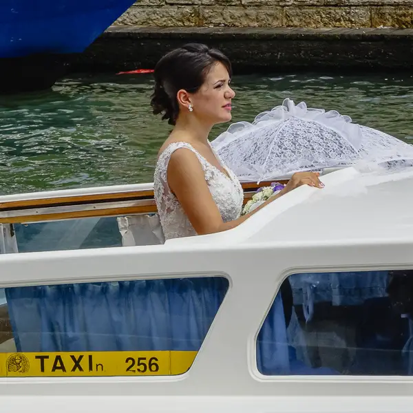 A bride rides in a Venice water taxi.