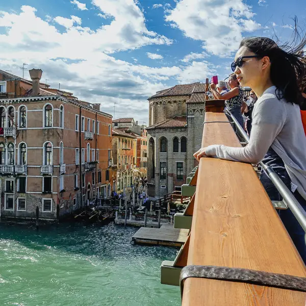 A tourist looks east from the Accademia Bridge in Venice, Italy.