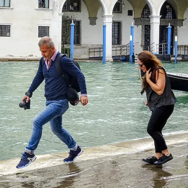 Visitors cope with a hint of 'acqua alta' on the Grand Canal.