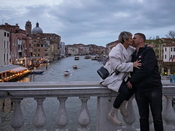 A couple shares a kiss on Venice's Rialto Bridge.