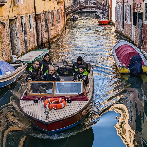 Firefighters and their fireboat navigate a canal in Venice, Italy.