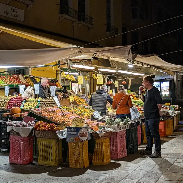 Customers shop at a produce stand in Venice's Cannaregio district.