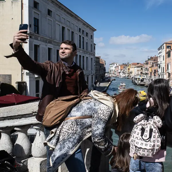 A tourist takes a selfie on the Rialto Bridge.