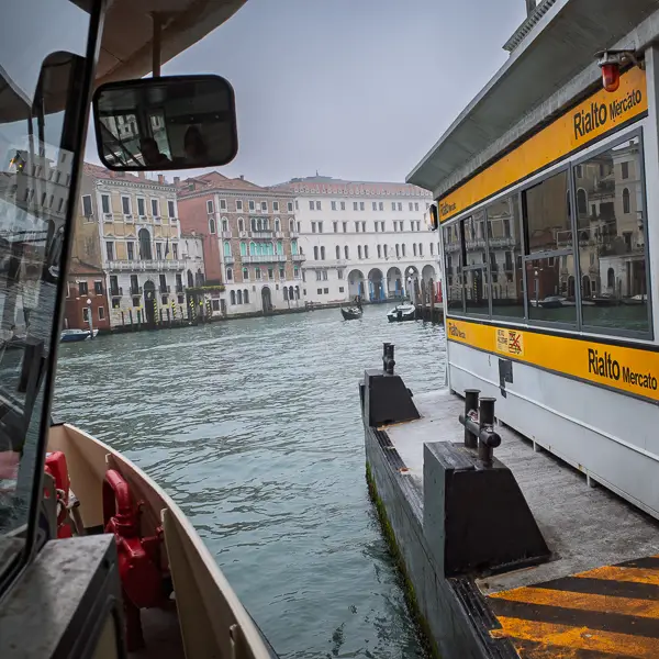 An ACTV vaporetto arrives at the Rialto Mercato waterbus stop on the Grand Canal.