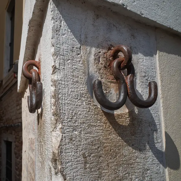 Tradition says that these hooks by Venice's San Canziano bridge once displayed pieces of drawn and quartered criminals, but nowadays Venetians touch them for good luck