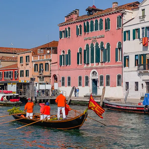 A rowing team passes the Hotel Tre Archi on the Cannaregio Canal in Venice. Italy.