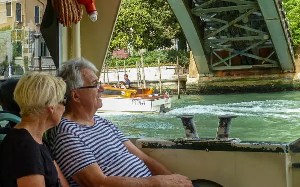 Passengers on an ACTV vaporetto as the water bus passes gbeneath Venice, Italy's Accademia Bridge.